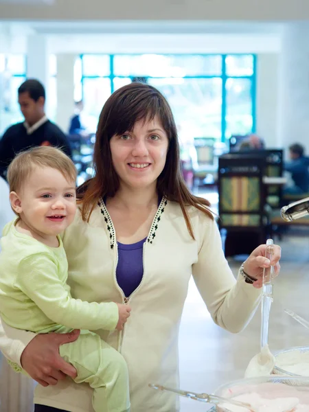 Женщина с ребенком, наливающая йогурт — стоковое фото