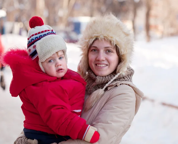 Счастливая мать с малышом зимой — стоковое фото