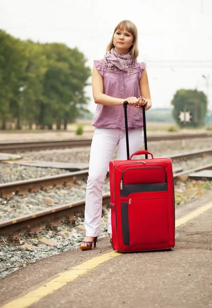 Женщина с багажом ждет поезд — стоковое фото