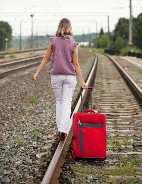 Femme avec bagages marchant sur le rail — Photo