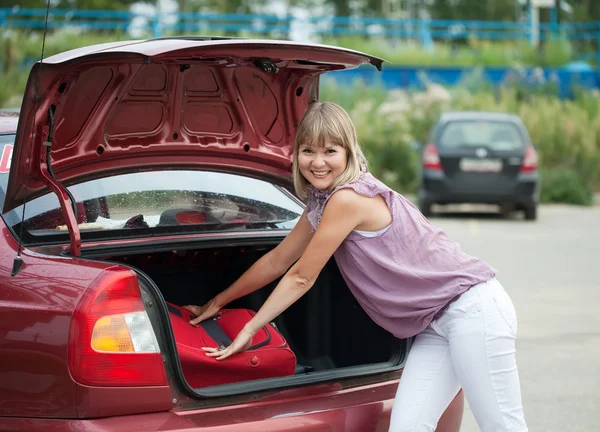 Frau packt ihr Gepäck in Auto — Stockfoto