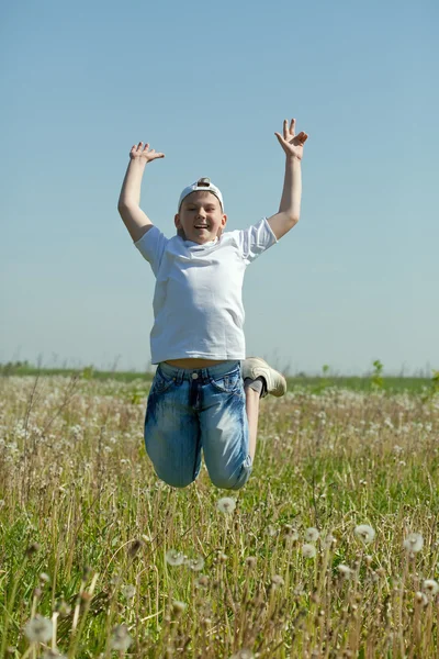 Gelukkige jongen springt op weide — Stockfoto
