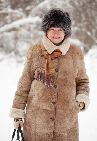 Volwassen vrouw in winterse bossen — Stockfoto