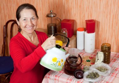 Mature woman brews herbs clipart