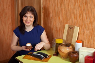 Woman salting raw fish clipart