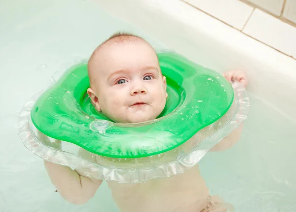 Six month baby swimming with neck swim ring — Stock Photo, Image