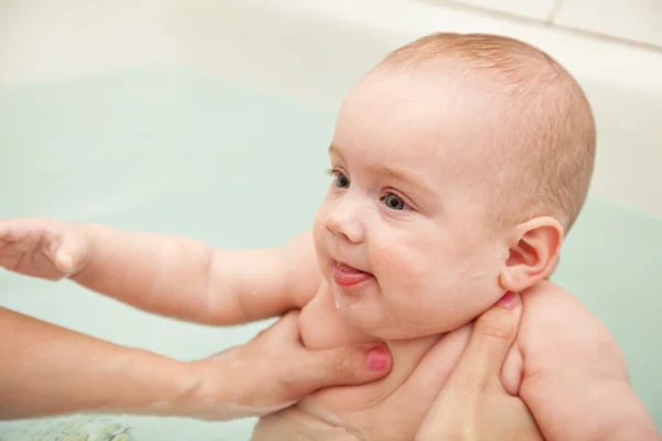 Baby swimming on mother 's hands — стоковое фото