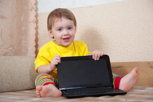 Niño se sienta con el ordenador portátil — Foto de Stock