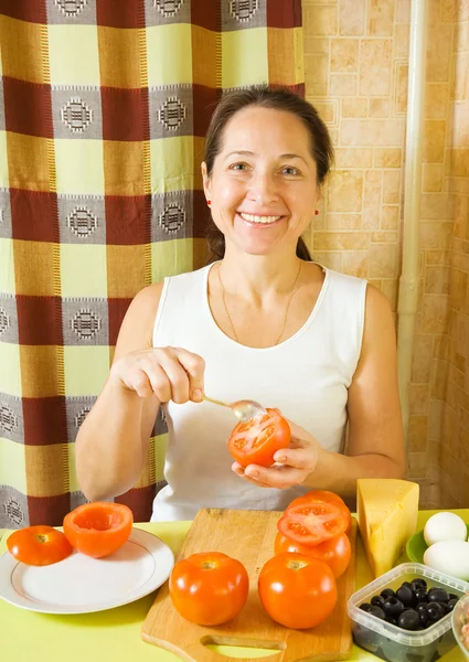 Mujer madura haciendo tomate relleno —  Fotos de Stock