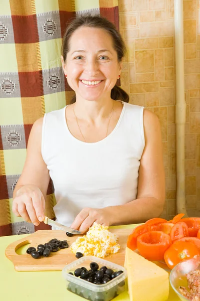 Woman cutting olive on cutting board — Stock Photo, Image