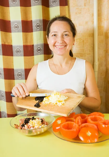 Femme ajoute des œufs râpés et des olives tranchées dans haché — Photo
