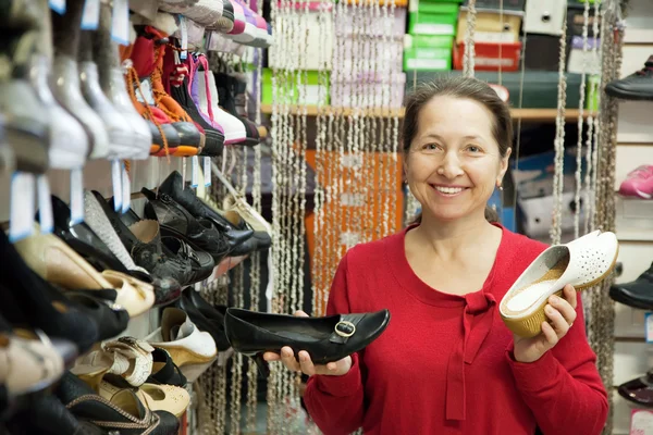 Volwassen vrouw kiest schoenen — Stockfoto