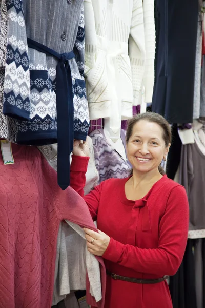 Mature woman chooses clothes — Stock Photo, Image
