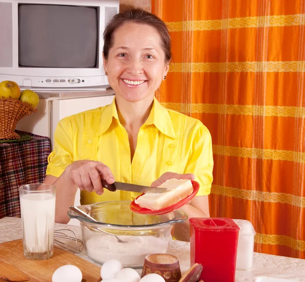 Frau fügt Margarine in Teig hinzu — Stockfoto