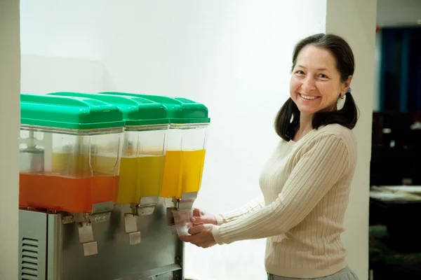Woman pours juice from container — Stock Photo, Image