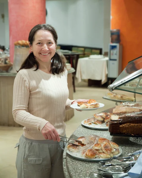 Vrouw kiest zoet gebak — Stockfoto
