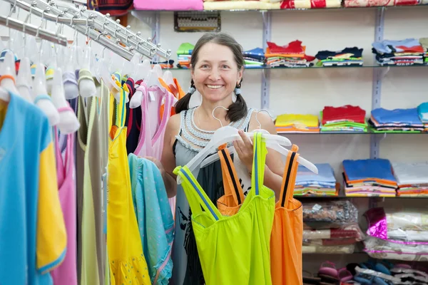 Kobieta wybiera ubrania w sklepie — Zdjęcie stockowe