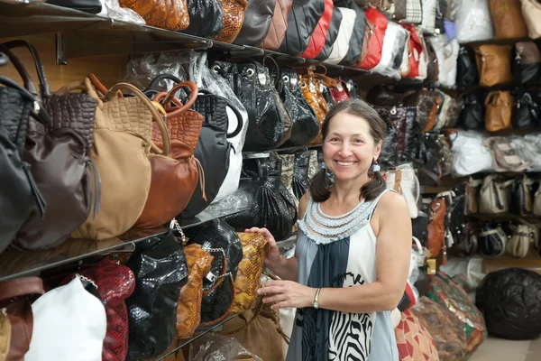Kobieta wybiera skórzana torba w sklepie — Zdjęcie stockowe