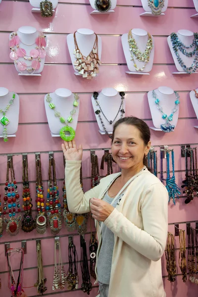Mature woman chooses beads — Stock Photo, Image