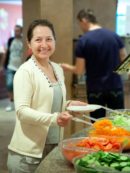 Kvinna tar färska grönsaker — Stockfoto