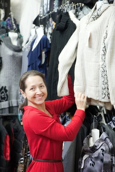 Mature woman chooses clothes Stock Image