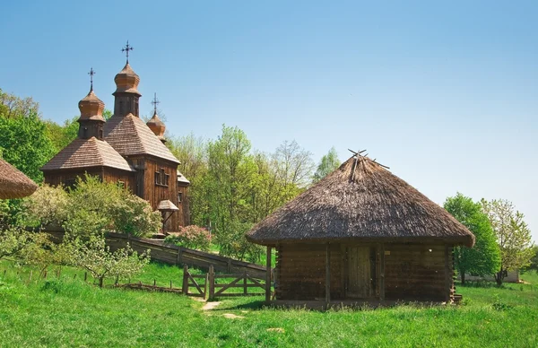Ukrainian old log hut and church — Stock Photo, Image