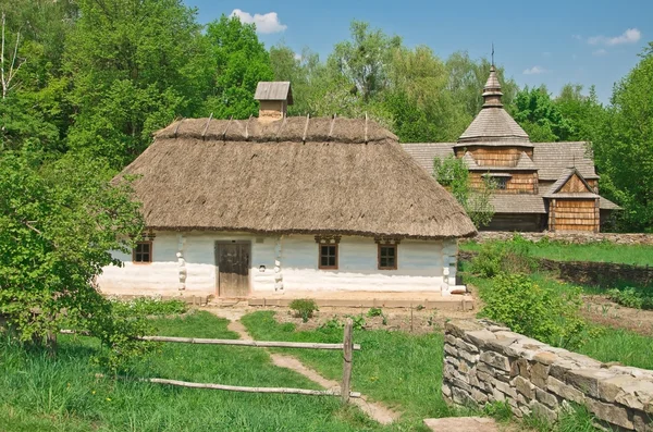 Ukrainska gamla logga hut och kyrkan — Stockfoto