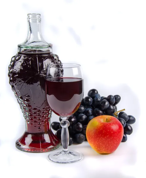 Старая бутылка и стакан с вином и фруктами — стоковое фото