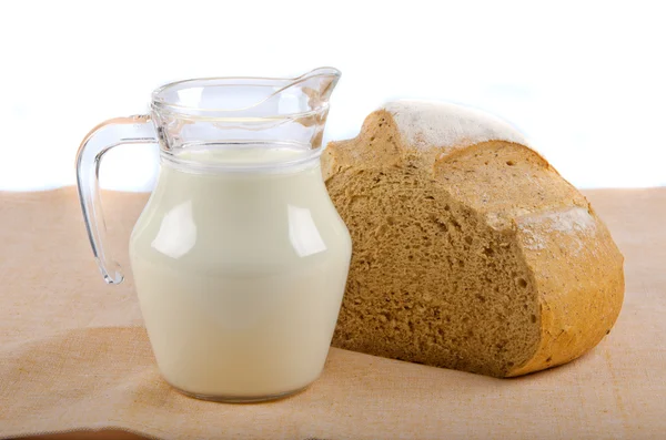 Bread and milk in pitcher — Stock Photo, Image