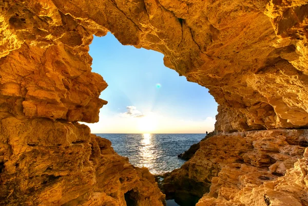 Solnedgang i grotten - Stock-foto