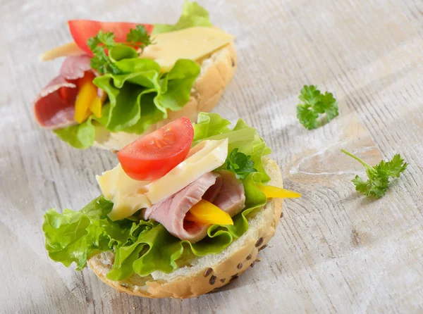 Бутерброди з шинкою, салатом і помідорами — стокове фото