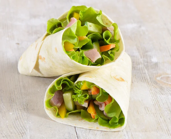 Fresh wrap sandwiches filled with ham, lettuce and pepper — Stock Photo, Image