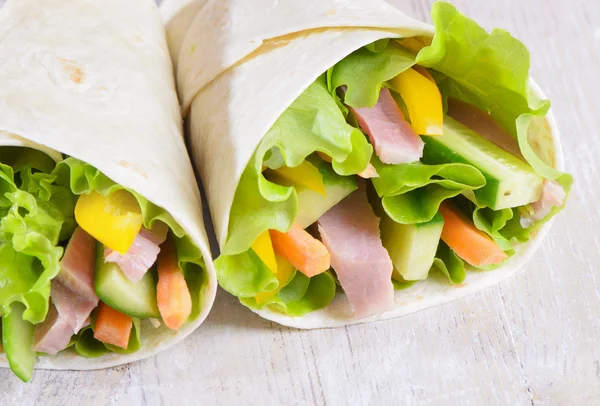 Fresh wrap sandwiches filled with ham, lettuce and pepper — Stock Photo, Image