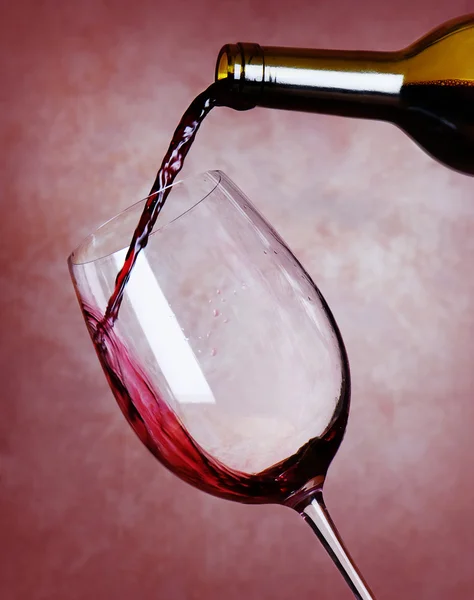 Vin rouge versant dans le verre à vin Images De Stock Libres De Droits