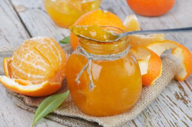 Orange jam on a wooden table clipart