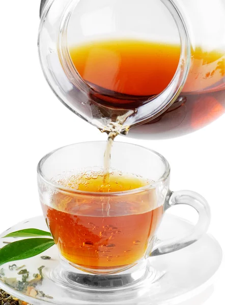 Tee, der isoliert auf weißem Hintergrund in Teetasse gegossen wird — Stockfoto