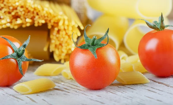Італійські макарони з помідорами на дерев'яний стіл — стокове фото