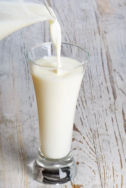 Glaskanne und Glas mit Milch — Stockfoto