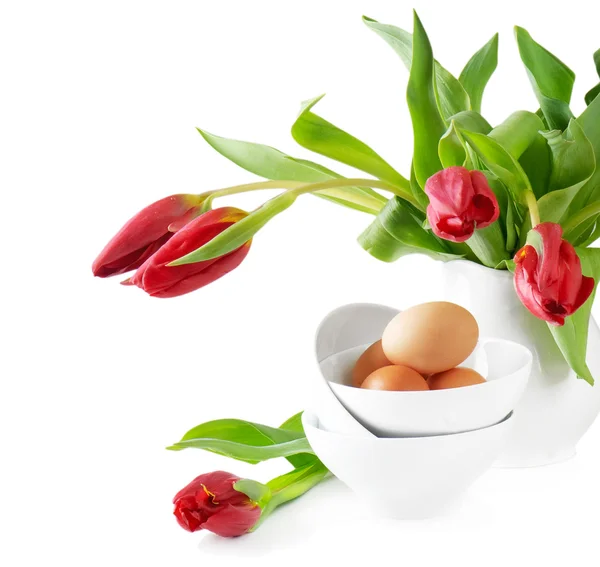 Пасхальные яйца и тюльпаны на белом фоне — стоковое фото