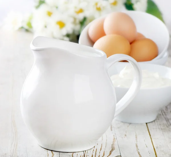 Jug with milk and eggs — Stock Photo, Image