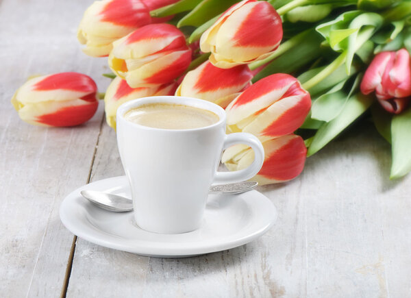 Coffee cup and red tulips