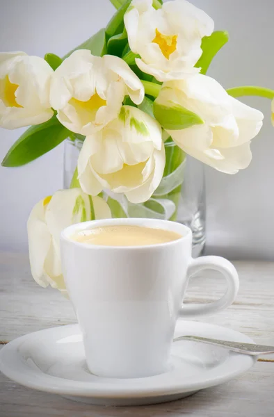 Coffee cup a bílé tulipány — Stock fotografie