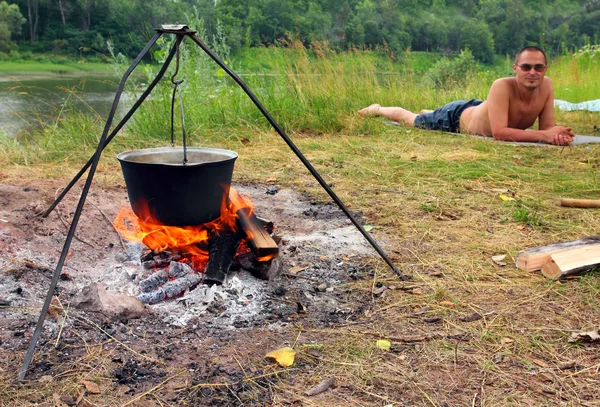 Camping - kettle and lying tourist — Stock Photo, Image