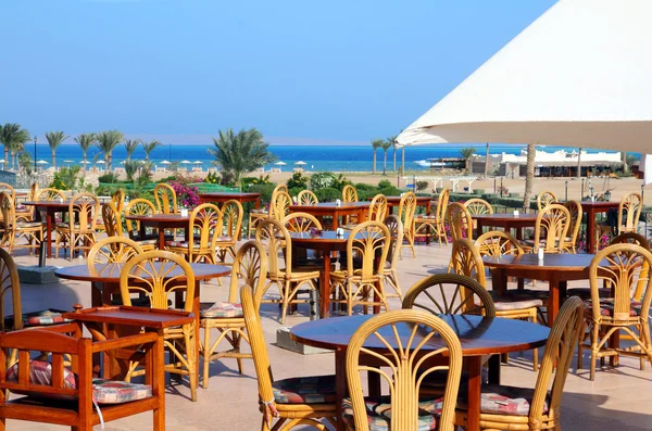 Tables dans café sur terrasse près de la mer — Photo