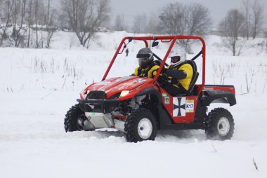 The quad bike's drivers ride over snow track clipart