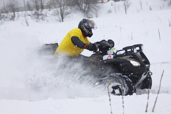 Motorista da moto quad cavalga sobre pista de neve — Fotografia de Stock