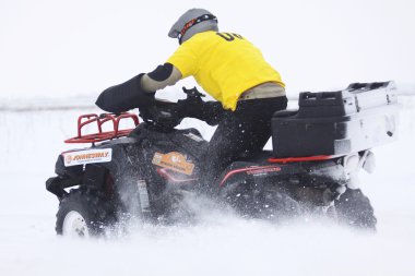 The quad bike's driver rides over snow track clipart