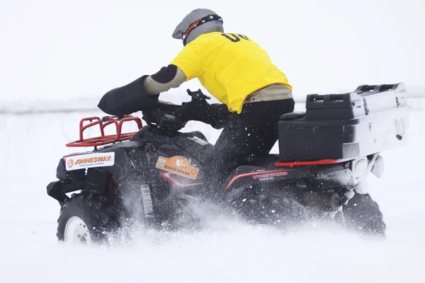Водитель квадроцикла едет по снежной трассе — стоковое фото