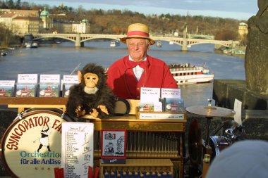 Street organ performer on Charles Bridge. Prague clipart