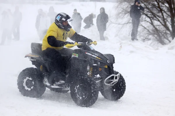 Motorista da moto quad cavalga sobre pista de neve — Fotografia de Stock
